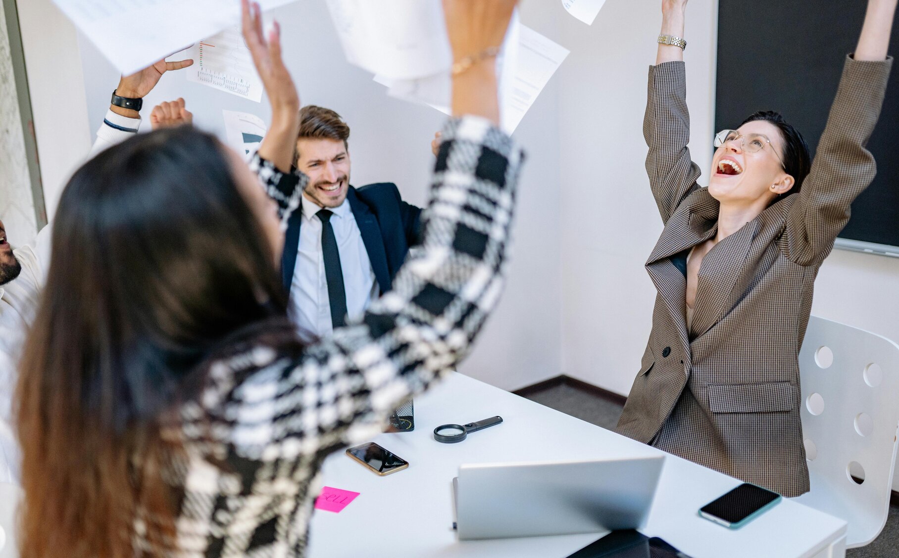 Menschen freuen sich und werden Papier in die Luft