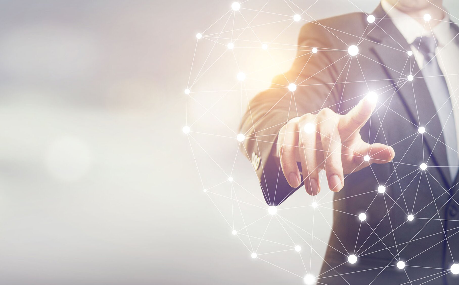 Ein Mann steht tippt auf das Hologramm eines Netzwerks.