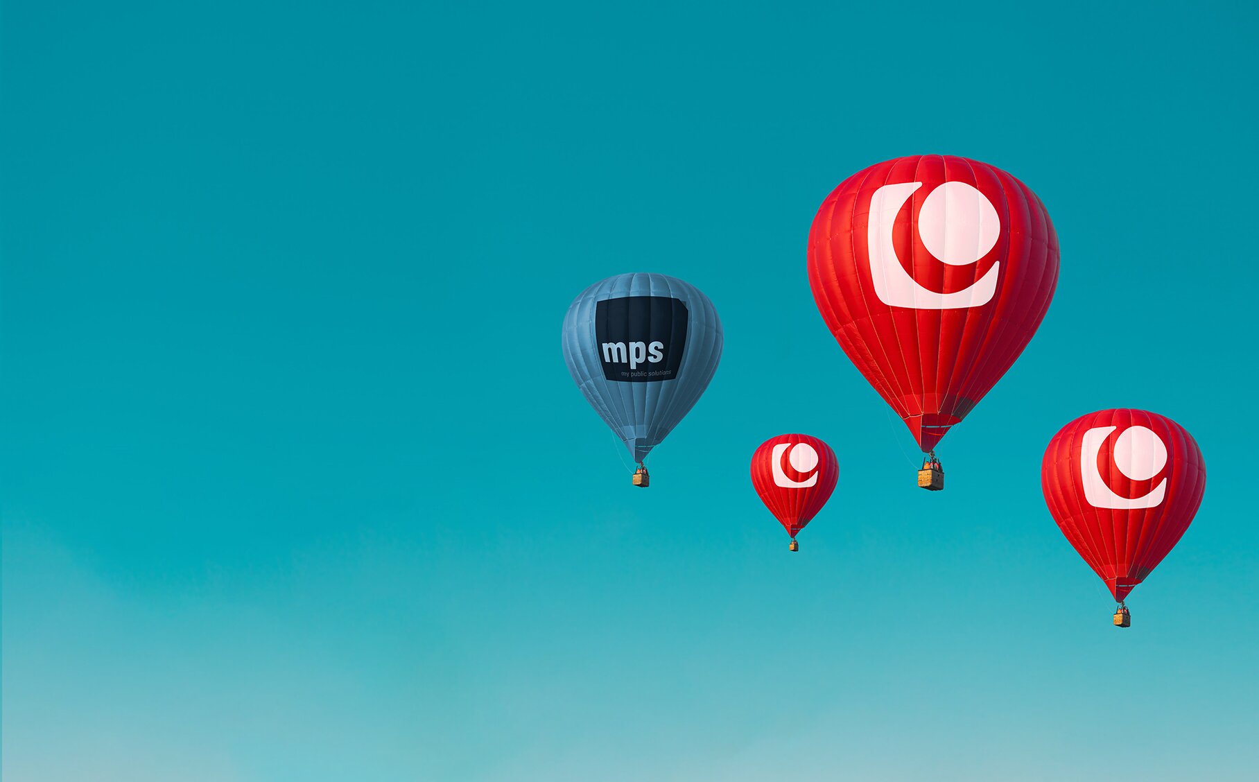 Vier Heißluftballons: Drei rote mit MACH Logo und ein blauer mit mps Logo. | © MACH AG