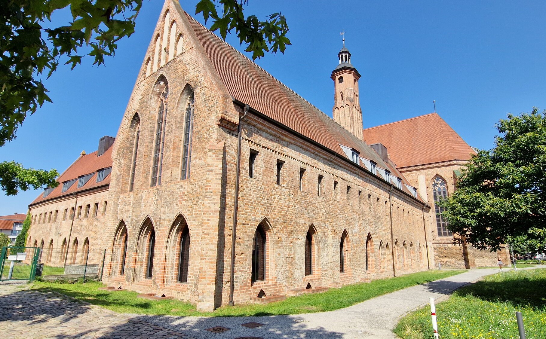 Außenansicht des Pauliklosters in Brandenburg an der Havel mit gotischer Backsteinfassade und Kirchturm unter blauem Himmel. | © Stadt Brandenburg an der Havel