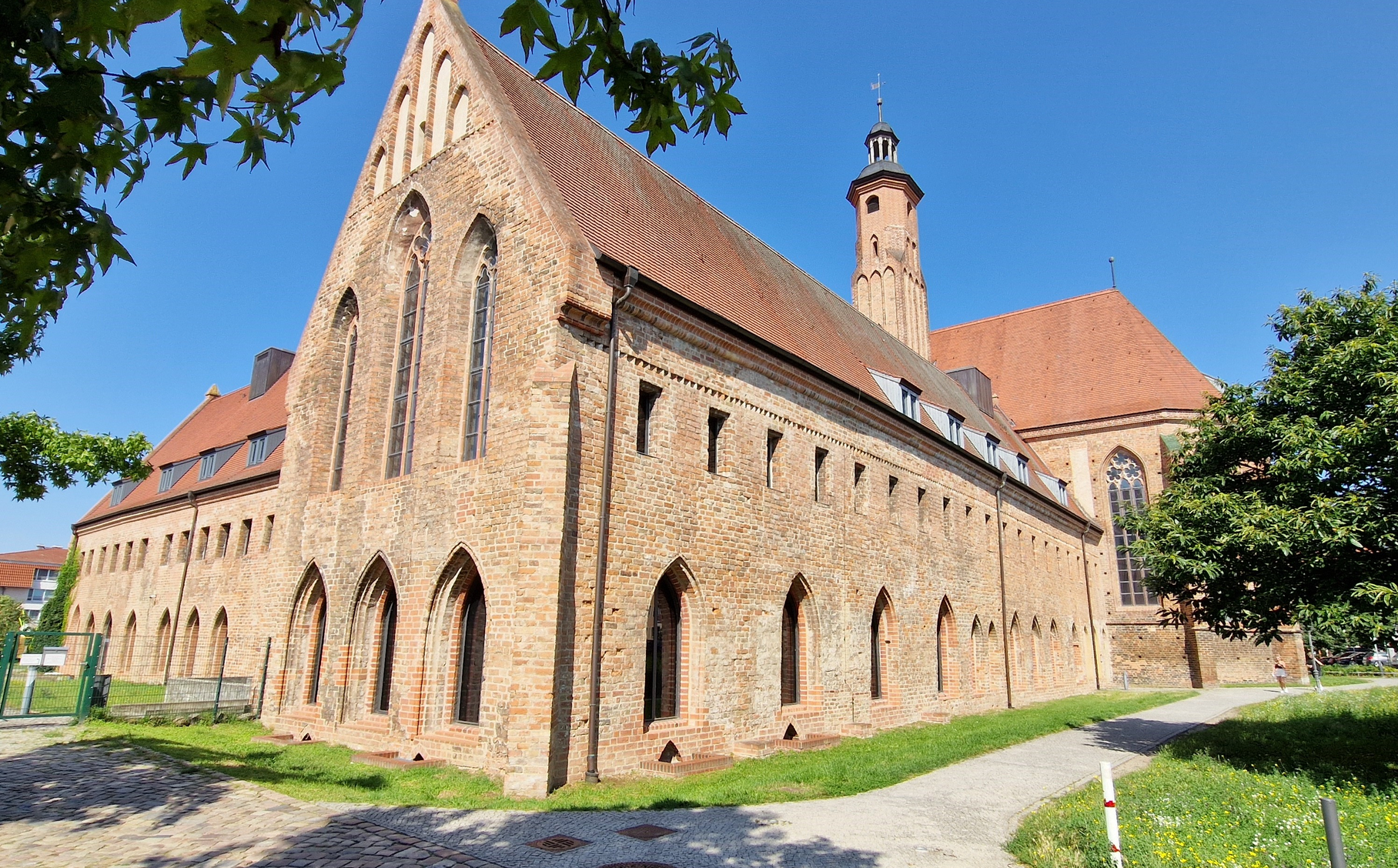 Außenansicht des Pauliklosters in Brandenburg an der Havel mit gotischer Backsteinfassade und Kirchturm unter blauem Himmel. | © Stadt Brandenburg an der Havel