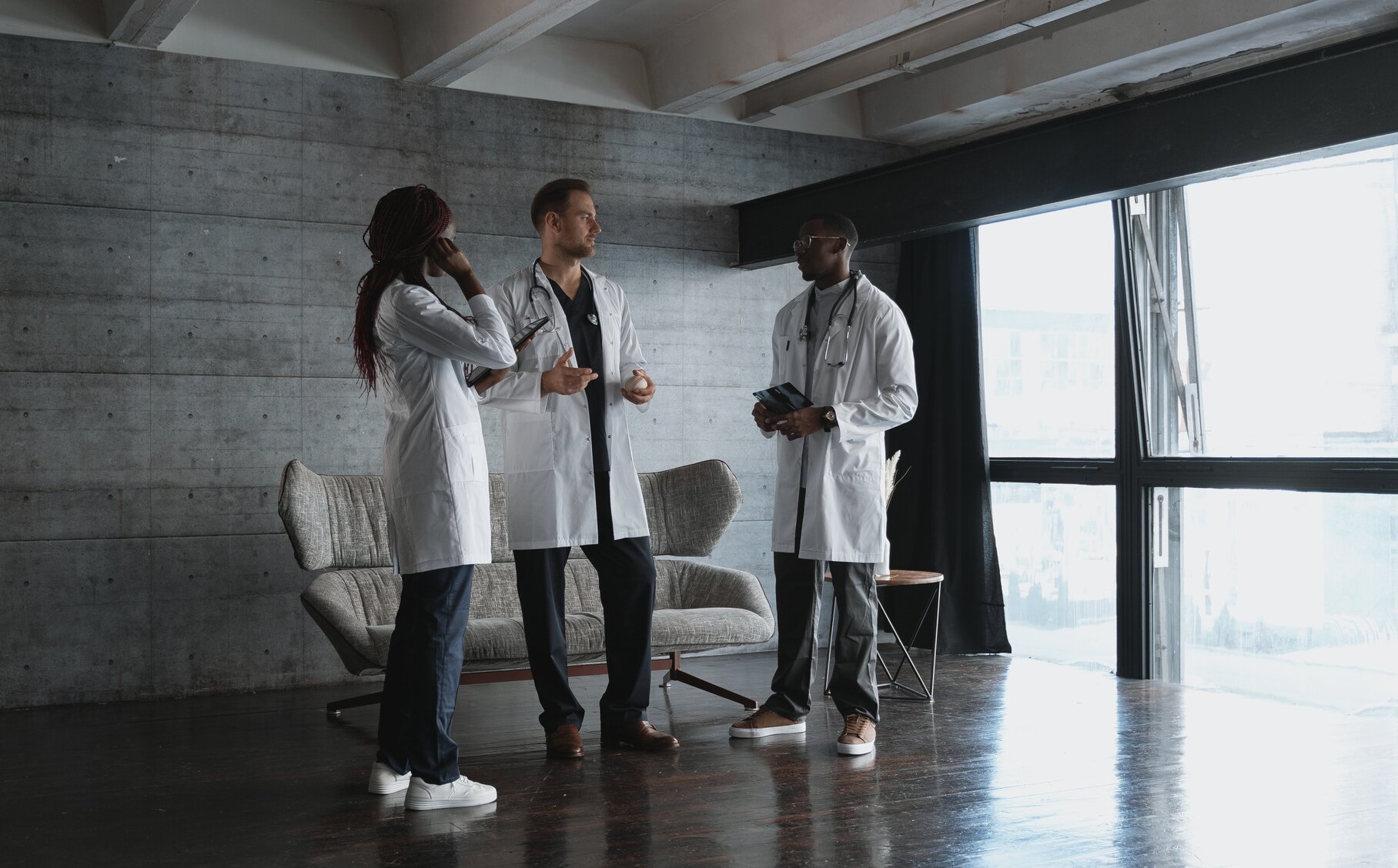 3 Ärtze mit weißem Kittel reden miteinander.