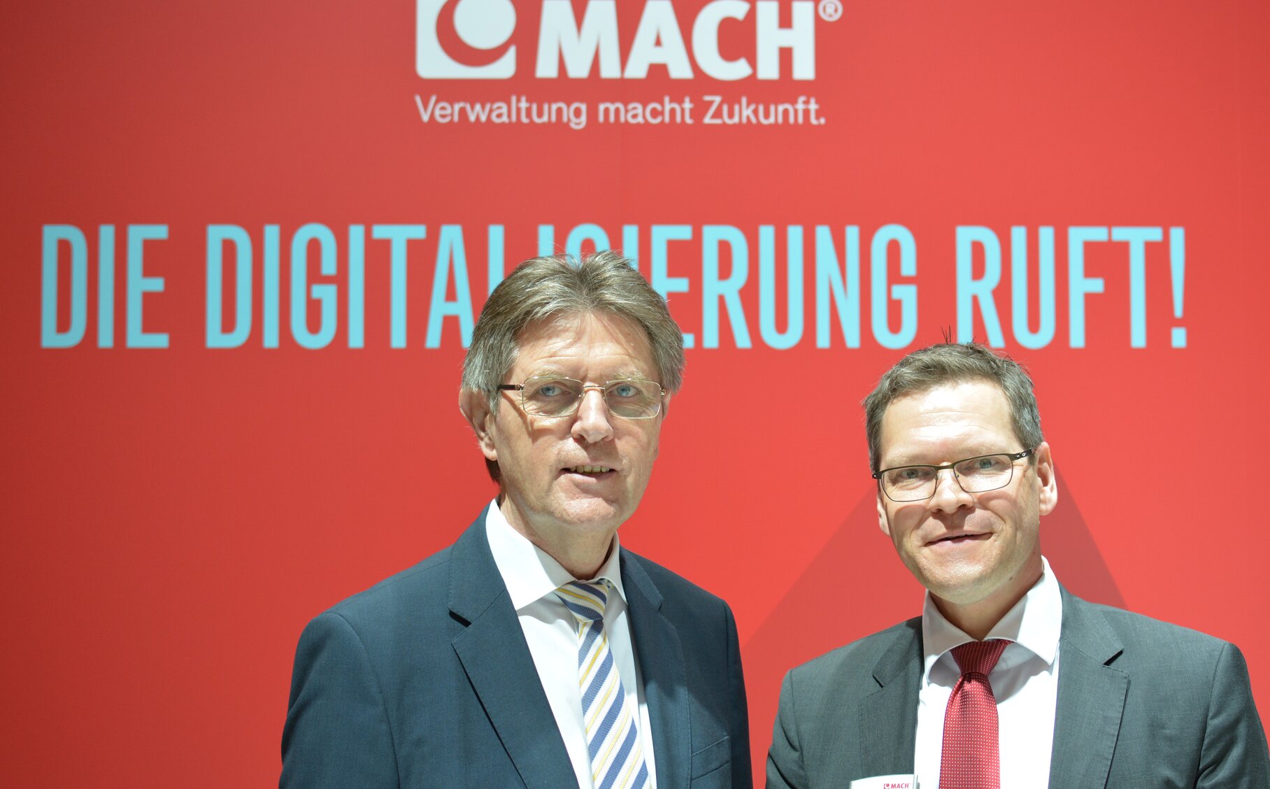 Zwei Männer vor der MACH Wand.