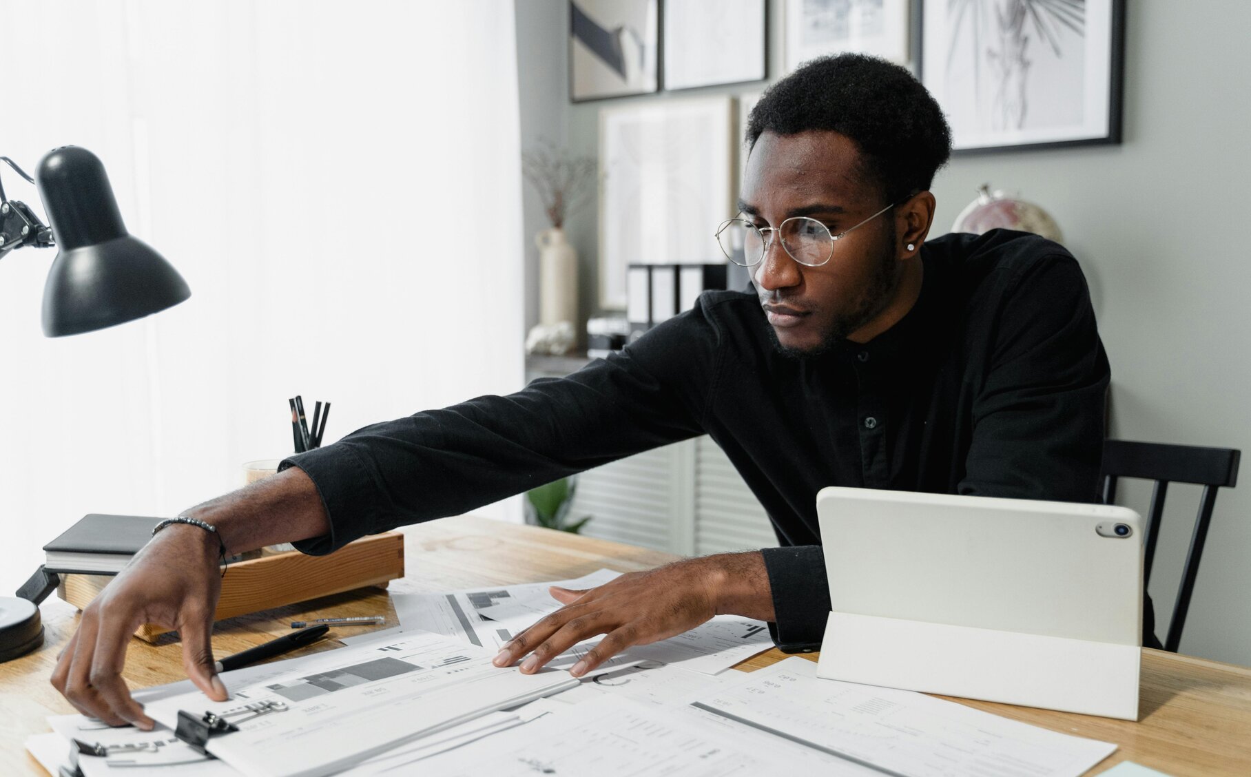 Eine Person sortiert Unterlagen auf ihrem Schreibtisch.