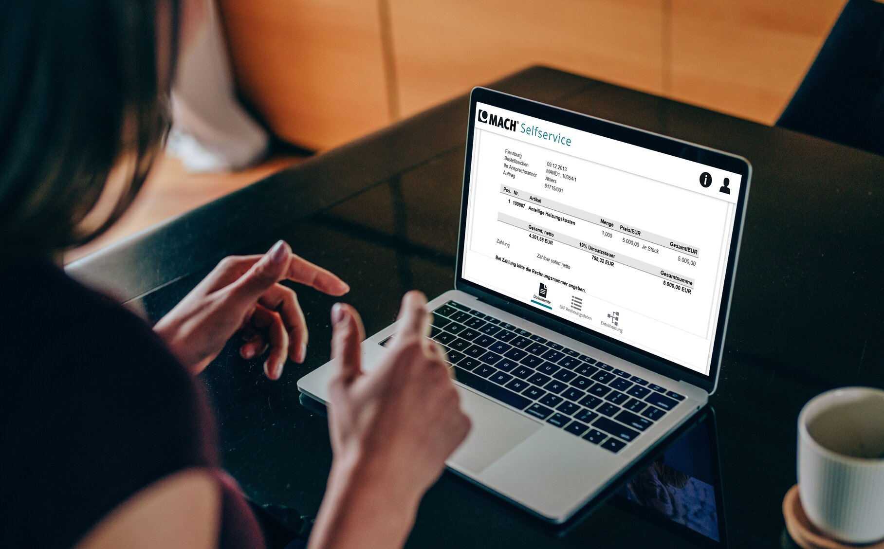 Mitarbeiterin der öffentlichen Verwaltung nutzt MACH Selfservice Software auf einem Laptop.